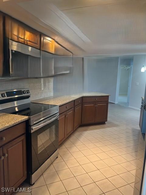 kitchen with baseboards, light tile patterned flooring, decorative backsplash, and stainless steel electric stove