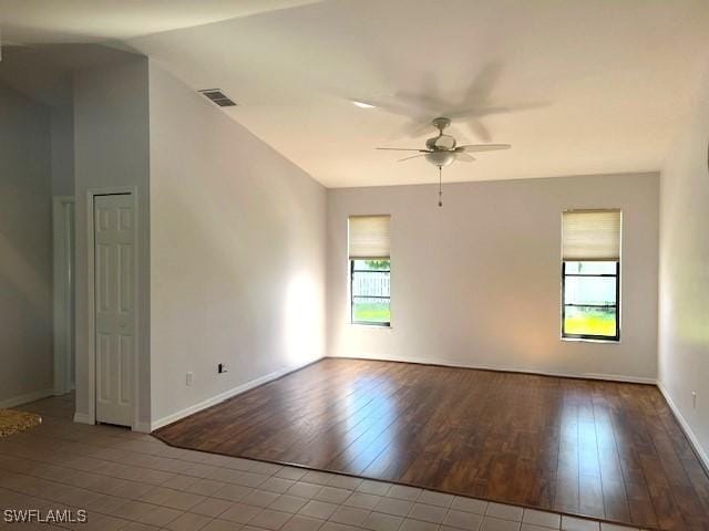 unfurnished room with baseboards, ceiling fan, visible vents, and wood finished floors