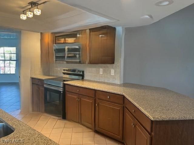 kitchen featuring light stone countertops, light tile patterned floors, stainless steel appliances, and decorative backsplash