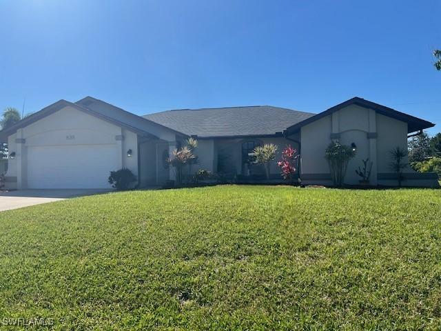 ranch-style house with an attached garage, concrete driveway, and a front yard