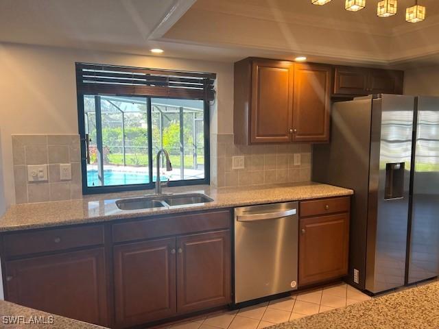 kitchen featuring light tile patterned floors, recessed lighting, decorative backsplash, appliances with stainless steel finishes, and a sink