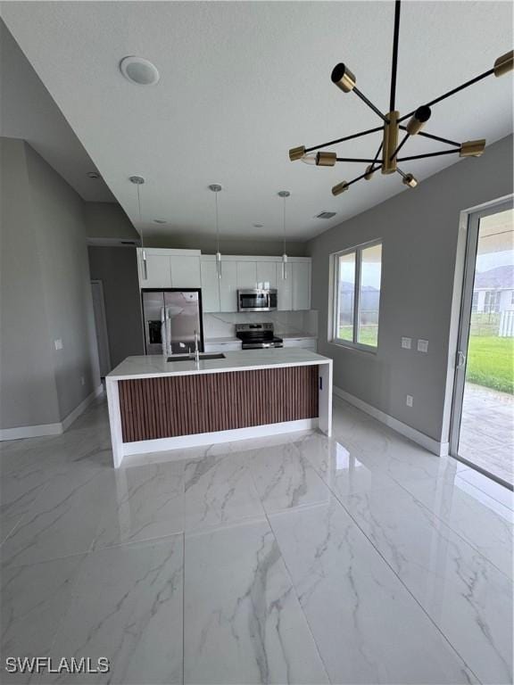 2610 34th St SW, Lehigh Acres, FL 33976 - kitchen featuring stainless steel appliances, baseboards, a sink, and healthy amount of natural light