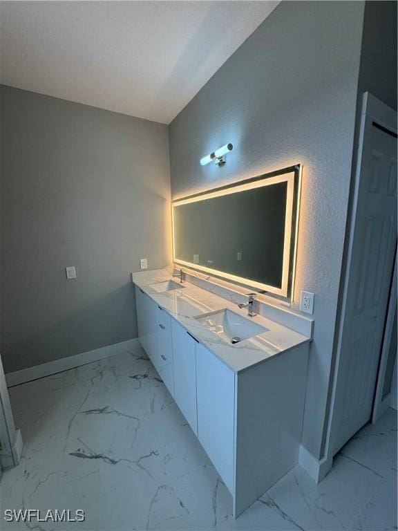 2610 34th St SW, Lehigh Acres, FL 33976 - full bathroom featuring marble finish flooring, baseboards, and double vanity