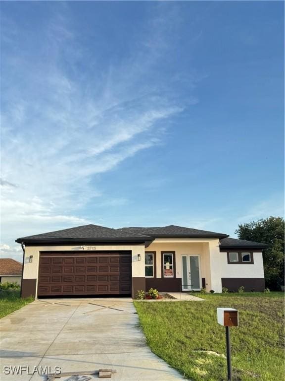 2610 34th St SW, Lehigh Acres, FL 33976 - prairie-style house with concrete driveway, a garage, stucco siding, and french doors