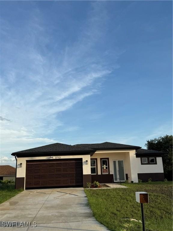 2610 34th St SW, Lehigh Acres, FL 33976 - prairie-style house with an attached garage, concrete driveway, stucco siding, a front yard, and french doors