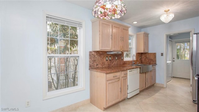 kitchen with pendant lighting, tasteful backsplash, dishwasher, sink, and light brown cabinets