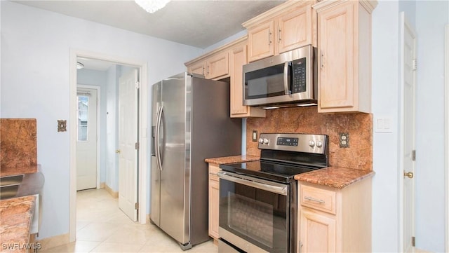 kitchen featuring appliances with stainless steel finishes, light brown cabinets, backsplash, and light tile patterned floors