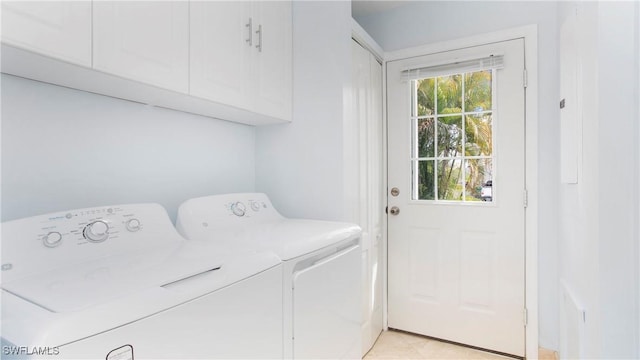 washroom with plenty of natural light, cabinets, and washing machine and clothes dryer