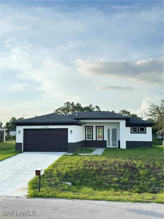 2713 26th St SW, Lehigh Acres, FL 33976 - view of front of home with stucco siding, an attached garage, driveway, french doors, and a front lawn
