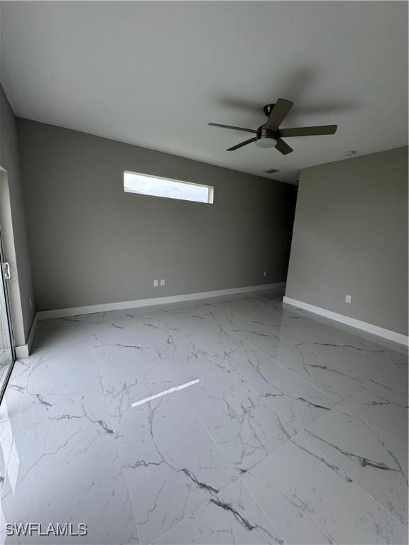 2713 26th St SW, Lehigh Acres, FL 33976 - unfurnished room featuring ceiling fan, baseboards, and light marble finish flooring