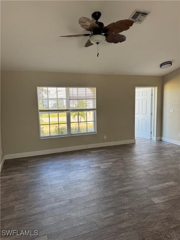 empty room with ceiling fan and dark hardwood / wood-style floors