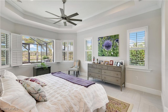 bedroom with ceiling fan, baseboards, a raised ceiling, and crown molding