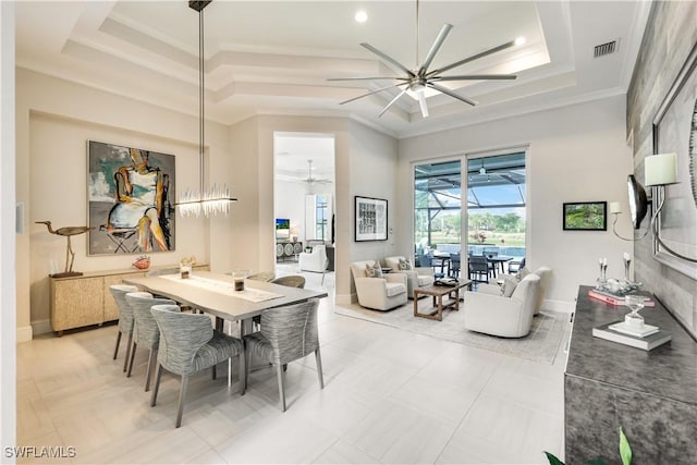 dining area with ceiling fan, a tray ceiling, a sunroom, and crown molding