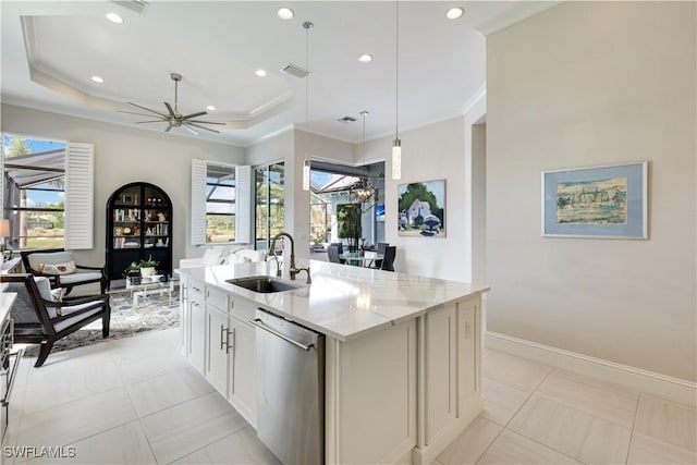 kitchen with an island with sink, light stone countertops, stainless steel dishwasher, white cabinetry, and a sink