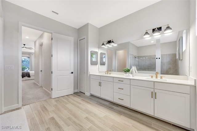 bathroom with walk in shower, ceiling fan, vanity, and hardwood / wood-style floors