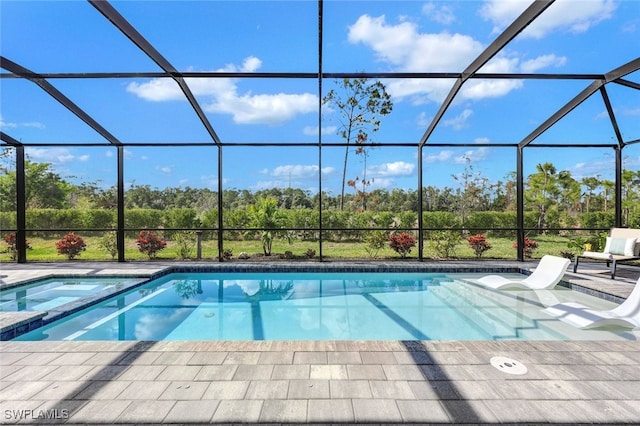 view of swimming pool with glass enclosure and a patio area