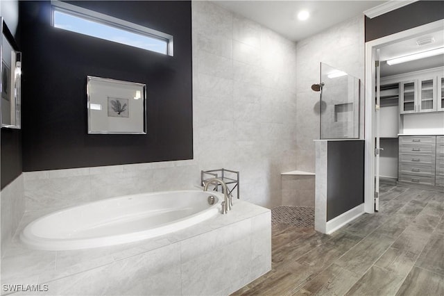 bathroom with separate shower and tub, tile walls, and hardwood / wood-style floors