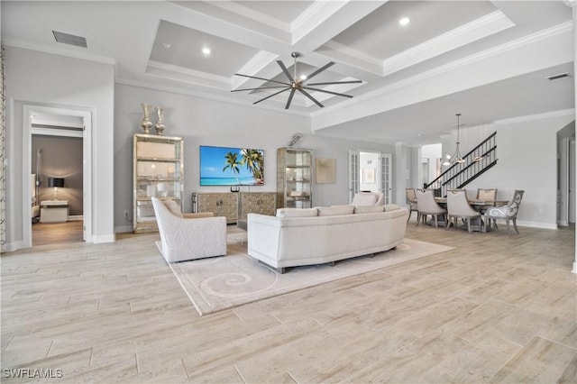 living room featuring coffered ceiling, ornamental molding, a chandelier, and light hardwood / wood-style floors