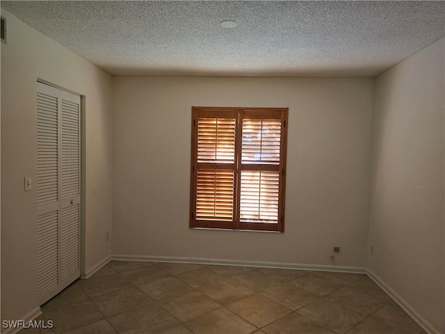 unfurnished bedroom featuring a textured ceiling and a closet