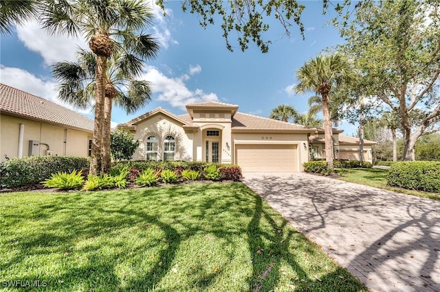 mediterranean / spanish home with a garage and a front lawn