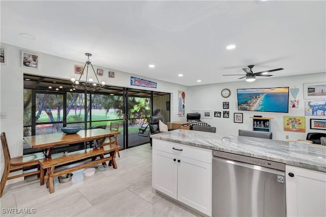 kitchen with light stone counters, stainless steel dishwasher, white cabinetry, and pendant lighting