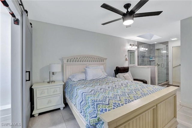 bedroom with light tile patterned floors, a barn door, and a ceiling fan