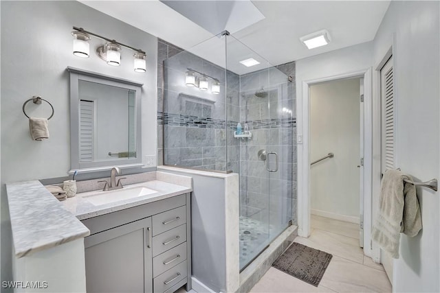 full bathroom with a closet, tile patterned flooring, vanity, and a stall shower