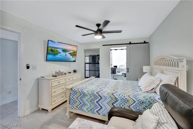 bedroom featuring light tile patterned flooring, ceiling fan, baseboards, and a barn door