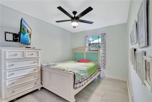 bedroom featuring light tile patterned floors, a ceiling fan, and baseboards