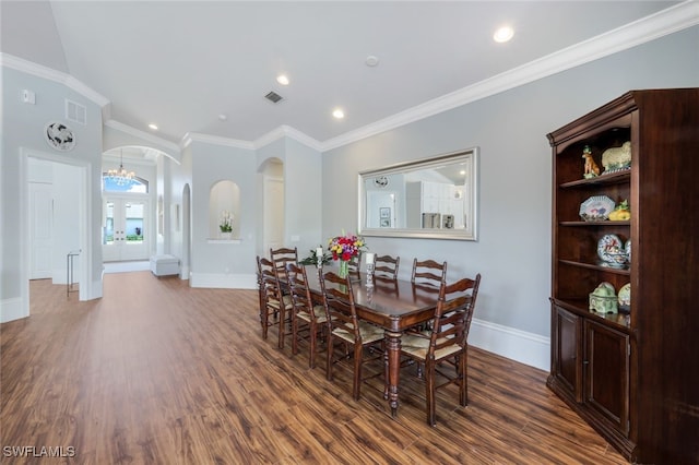 dining room with dark wood-style floors, arched walkways, and baseboards