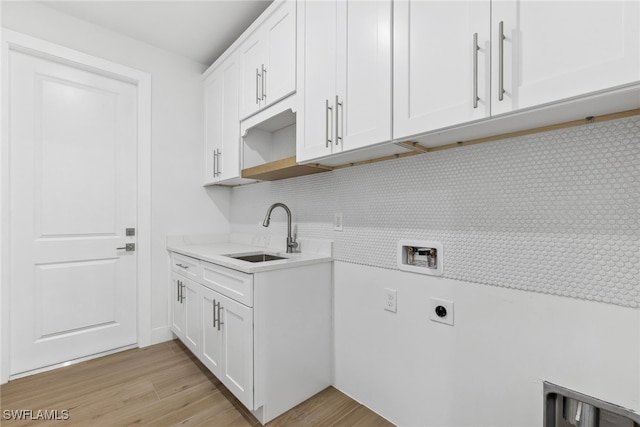 laundry area with washer hookup, hookup for an electric dryer, a sink, and light wood finished floors