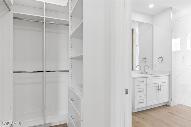 spacious closet with a sink and light wood-style floors