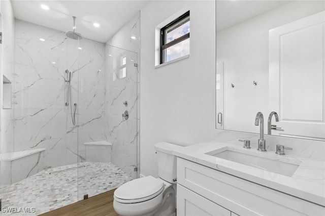 bathroom with toilet, recessed lighting, a marble finish shower, and vanity