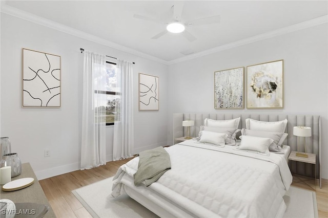 bedroom featuring ornamental molding, baseboards, light wood finished floors, and a ceiling fan