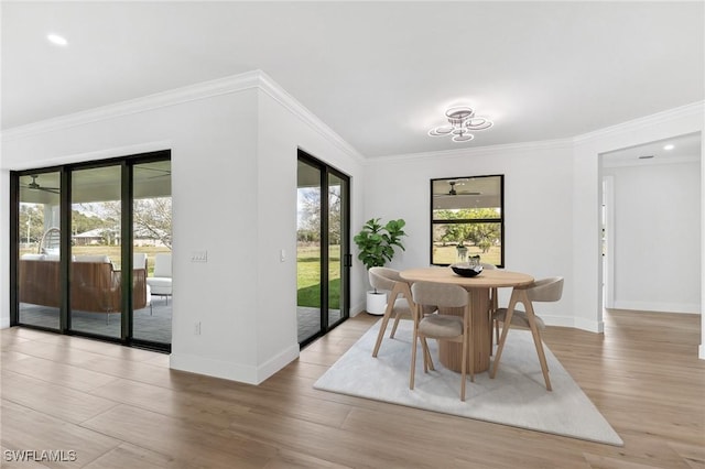 dining room featuring crown molding, light wood-style flooring, and baseboards