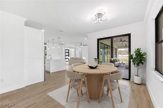 dining area with ornamental molding, baseboards, visible vents, and light wood finished floors