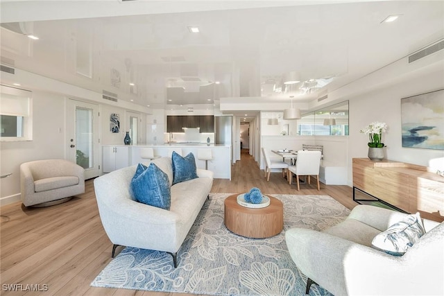 living area featuring visible vents and light wood finished floors