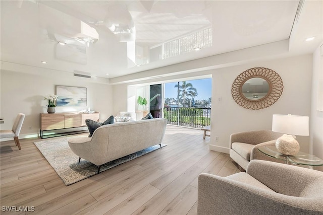 living room with light wood-style flooring, baseboards, and recessed lighting