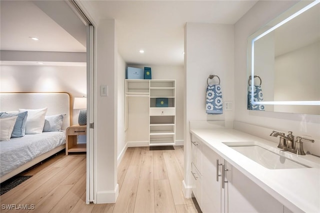 bathroom featuring wood finished floors, vanity, and recessed lighting