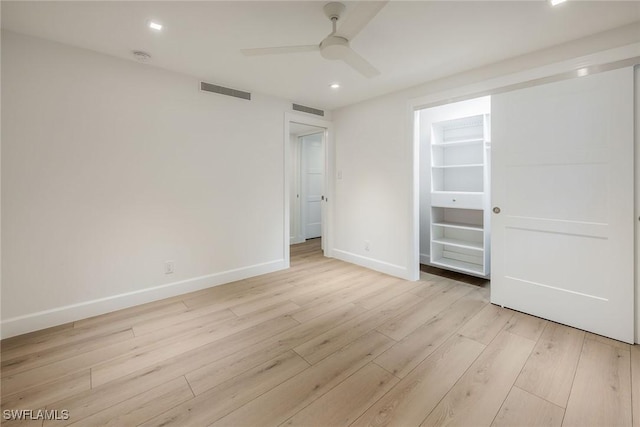 unfurnished room featuring a ceiling fan, baseboards, visible vents, and light wood finished floors