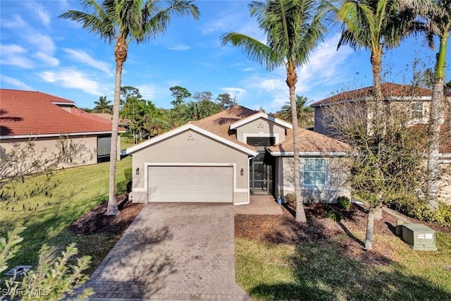 mediterranean / spanish-style home featuring decorative driveway, an attached garage, a front lawn, and stucco siding