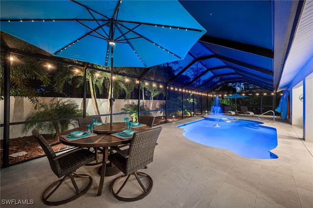 5548 Foxhunt Way, Naples, FL 34104 - pool at night featuring a patio area, a pool with connected hot tub, outdoor dining area, and a lanai