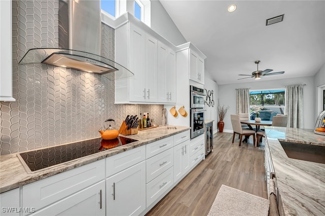 5548 Foxhunt Way, Naples, FL 34104 - kitchen featuring wall chimney range hood, black electric cooktop, beverage cooler, a sink, and white cabinetry