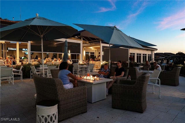 5548 Foxhunt Way, Naples, FL 34104 - patio terrace at dusk with an outdoor fire pit and a patio area