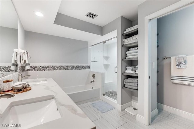 bathroom featuring a bath, a stall shower, visible vents, and a sink