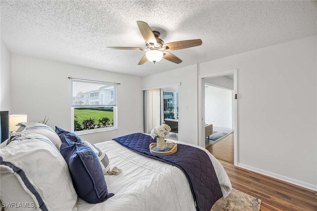 bedroom with ceiling fan, dark hardwood / wood-style floors, and a textured ceiling