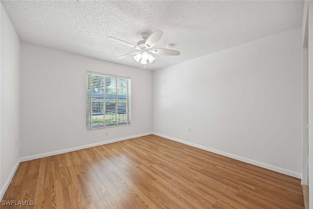 empty room with a textured ceiling, ceiling fan, and light hardwood / wood-style flooring