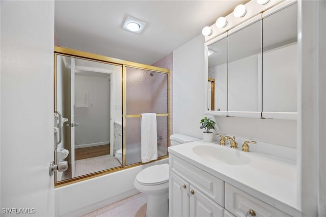 full bathroom featuring vanity, toilet, and combined bath / shower with glass door