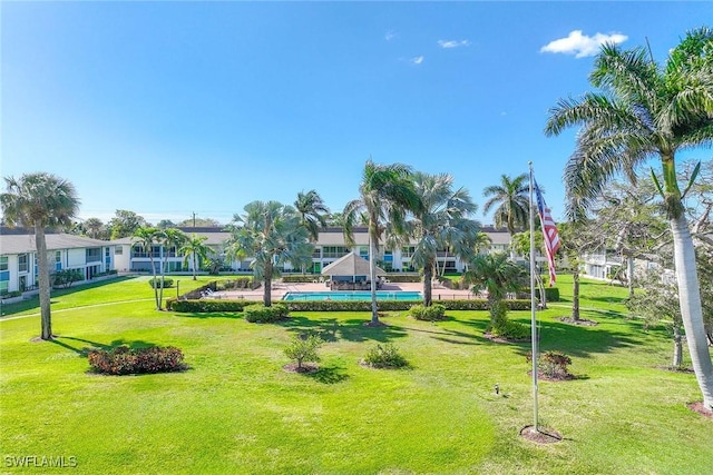 view of home's community featuring a swimming pool and a lawn