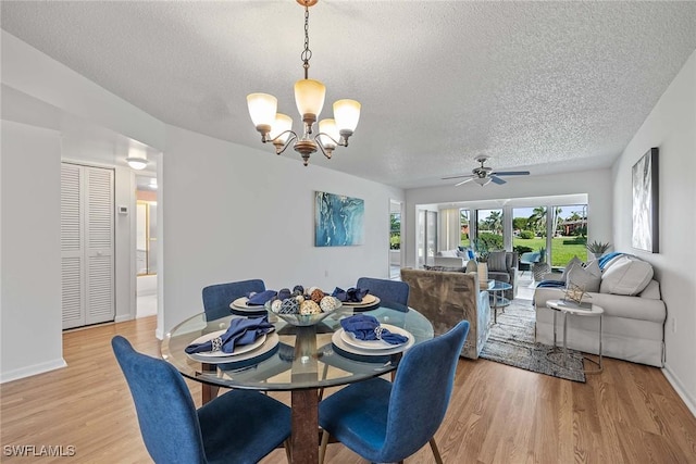 dining area with ceiling fan with notable chandelier, light hardwood / wood-style floors, and a textured ceiling